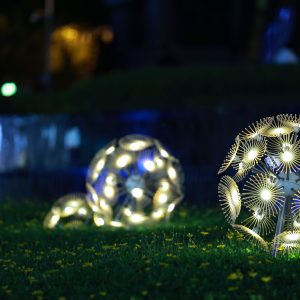 Artistic glowing spheres illuminate a garden at night, creating a magical atmosphere.